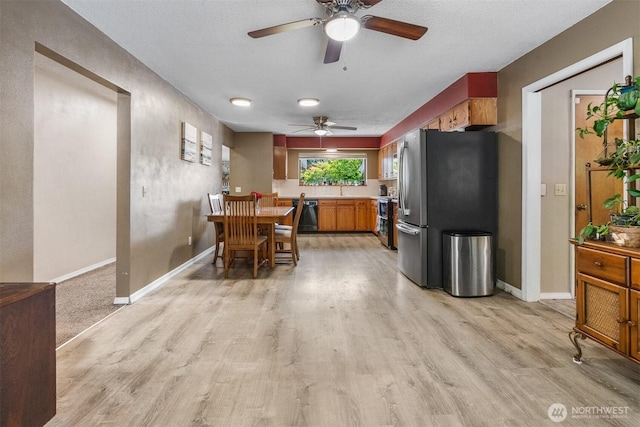 209 Old Hill Rd, Aberdeen, WA 98520 - kitchen featuring freestanding refrigerator, a ceiling fan, light wood-style flooring, brown cabinets, and light countertops