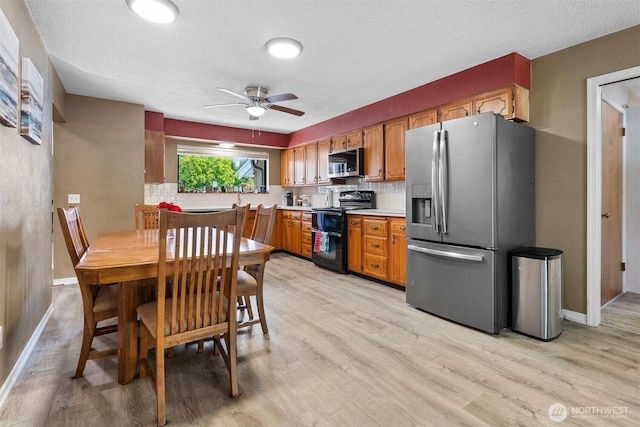 209 Old Hill Rd, Aberdeen, WA 98520 - kitchen featuring stainless steel appliances, light wood-style floors, a ceiling fan, light countertops, and a textured ceiling