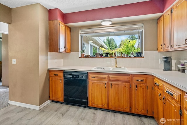 209 Old Hill Rd, Aberdeen, WA 98520 - kitchen featuring black dishwasher, light wood-style flooring, light countertops, and tasteful backsplash
