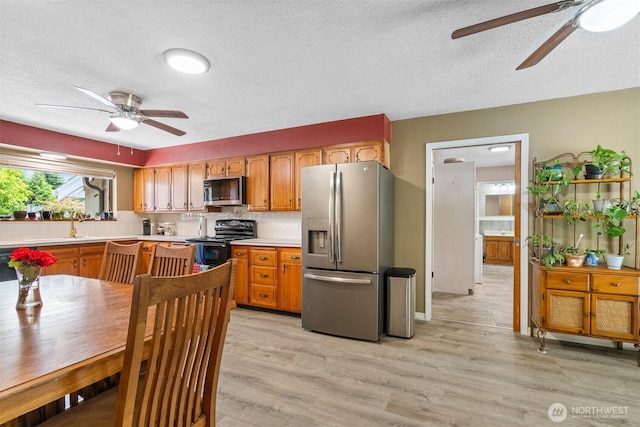 209 Old Hill Rd, Aberdeen, WA 98520 - kitchen featuring appliances with stainless steel finishes, a ceiling fan, light countertops, light wood-type flooring, and a textured ceiling