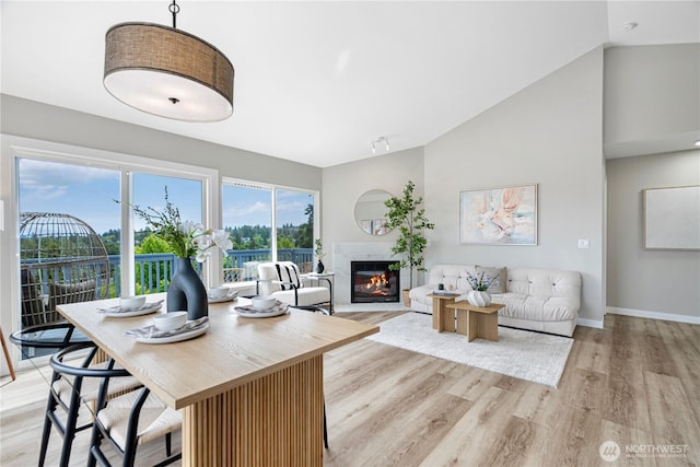 9422 49th Ave S, Seattle, WA 98118 - living room with light wood-style floors, a glass covered fireplace, and vaulted ceiling
