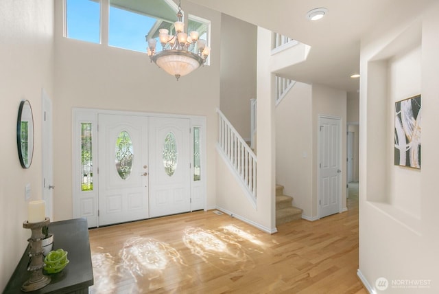 27638 246th Ave SE, Maple Valley, WA 98038 - foyer with a chandelier, stairway, wood finished floors, and a high ceiling