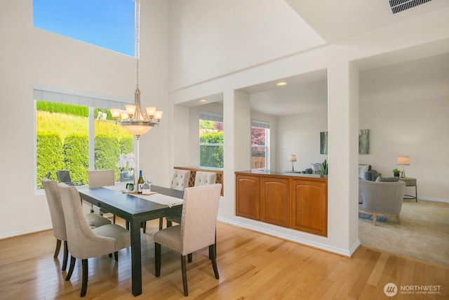 27638 246th Ave SE, Maple Valley, WA 98038 - dining area featuring light wood-type flooring, a chandelier, plenty of natural light, and a towering ceiling