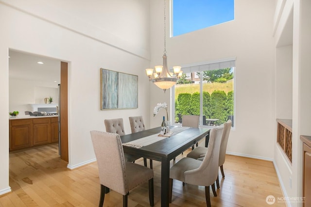 27638 246th Ave SE, Maple Valley, WA 98038 - dining space featuring a chandelier, light wood-style flooring, a high ceiling, and recessed lighting