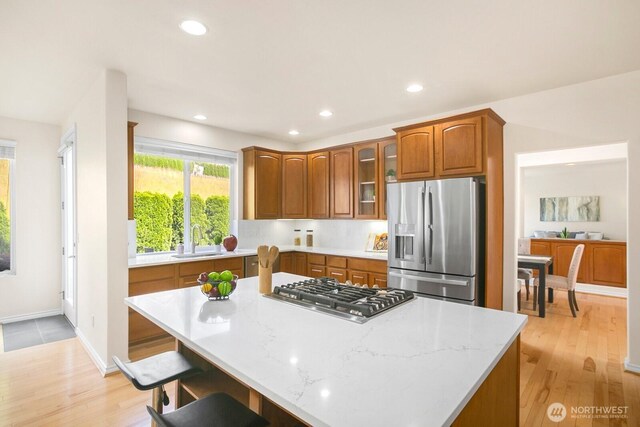27638 246th Ave SE, Maple Valley, WA 98038 - kitchen with appliances with stainless steel finishes, light wood finished floors, recessed lighting, a center island, and brown cabinets