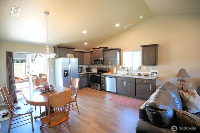 1028 W Sequoia Rd, Moses Lake, WA 98837 - kitchen with stainless steel appliances, a sink, dark brown cabinets, light wood-style floors, and recessed lighting