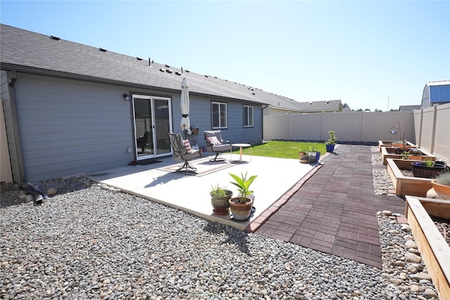 1028 W Sequoia Rd, Moses Lake, WA 98837 - fenced backyard featuring a patio area and a vegetable garden
