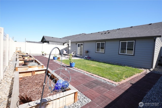 1028 W Sequoia Rd, Moses Lake, WA 98837 - rear view of house featuring a garden, a patio area, and a shingled roof