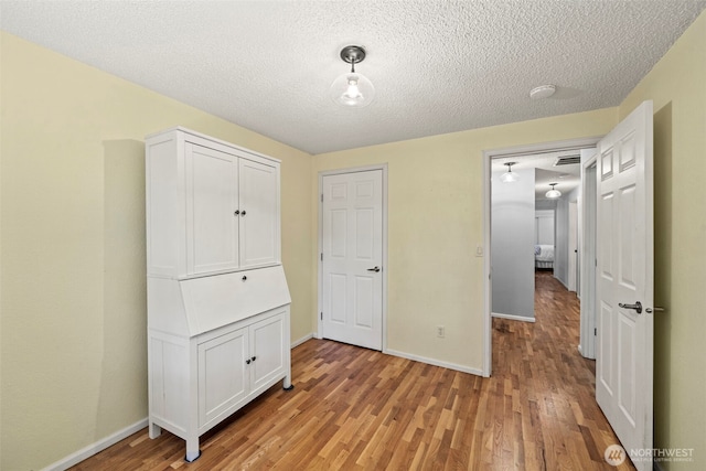 2112 SE Yucca Ct, Port Orchard, WA 98366 - unfurnished bedroom with light wood-style flooring, baseboards, and a textured ceiling