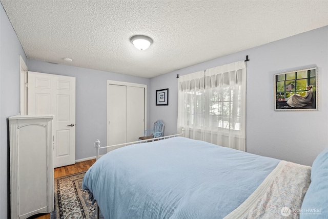 2112 SE Yucca Ct, Port Orchard, WA 98366 - bedroom featuring wood finished floors, a closet, a textured ceiling, and baseboards
