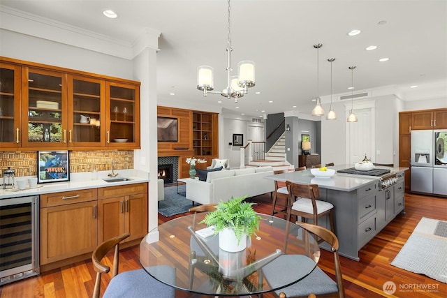 8418SE 44th St, Mercer Island, WA 98040 - dining space with wine cooler, recessed lighting, crown molding, stairs, and a warm lit fireplace