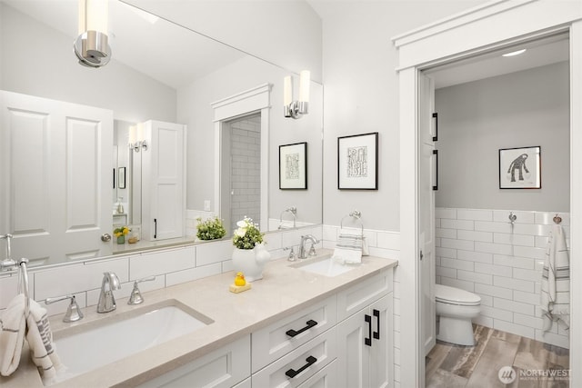 8418SE 44th St, Mercer Island, WA 98040 - full bathroom featuring toilet, double vanity, tile walls, wainscoting, and wood finished floors
