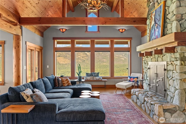 67 Goudy Grade Rd, Winthrop, WA 98862 - living area featuring a stone fireplace, wood finished floors, wooden ceiling with exposed beams, a chandelier, and high vaulted ceiling