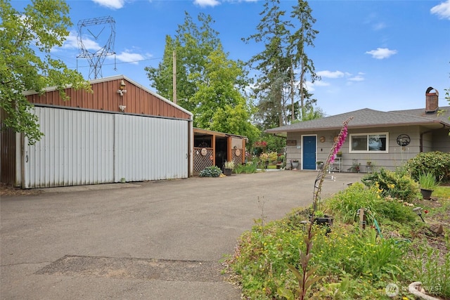 236 Newaukum Valley Rd, Chehalis, WA 98532 - view of front facade featuring a chimney, an outdoor structure, a detached garage, and a pole building