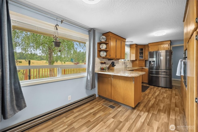 236 Newaukum Valley Rd, Chehalis, WA 98532 - kitchen featuring stainless steel appliances, baseboard heating, brown cabinets, a peninsula, and light wood finished floors