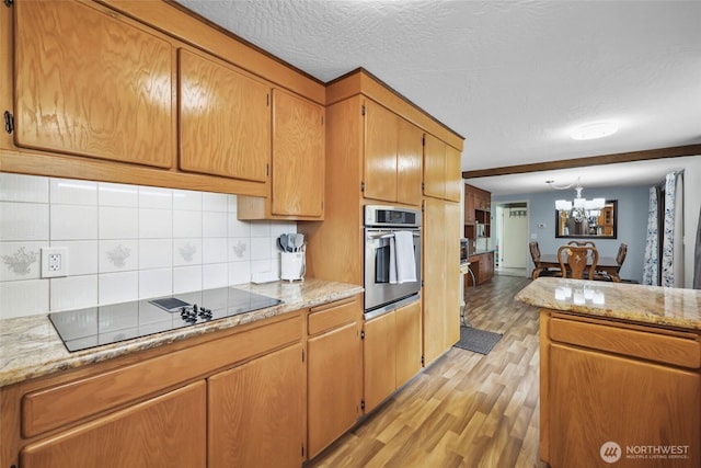 236 Newaukum Valley Rd, Chehalis, WA 98532 - kitchen featuring stainless steel oven, black electric stovetop, light wood-type flooring, decorative backsplash, and a chandelier