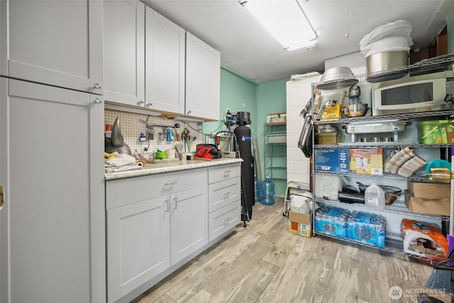 236 Newaukum Valley Rd, Chehalis, WA 98532 - kitchen with light wood finished floors, light countertops, white cabinets, and stainless steel microwave