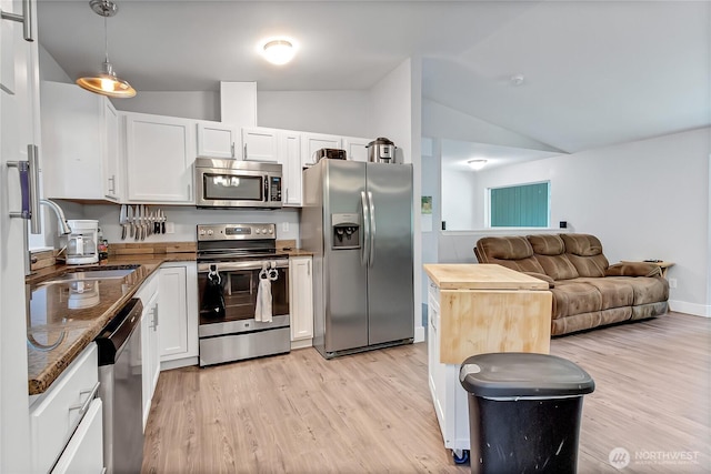 17642 Vine Ln SE, Yelm, WA 98597 - kitchen with appliances with stainless steel finishes, a sink, vaulted ceiling, open floor plan, and white cabinets