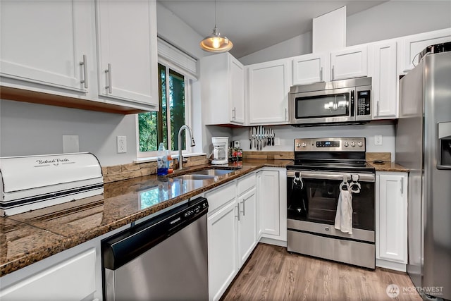 17642 Vine Ln SE, Yelm, WA 98597 - kitchen with stainless steel appliances, a sink, white cabinetry, vaulted ceiling, and light wood-style flooring