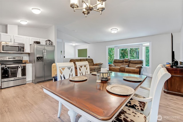 17642 Vine Ln SE, Yelm, WA 98597 - dining area featuring vaulted ceiling, light wood finished floors, and a chandelier