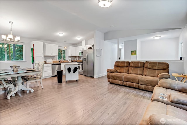 17642 Vine Ln SE, Yelm, WA 98597 - living room featuring lofted ceiling, a chandelier, and light wood-style floors