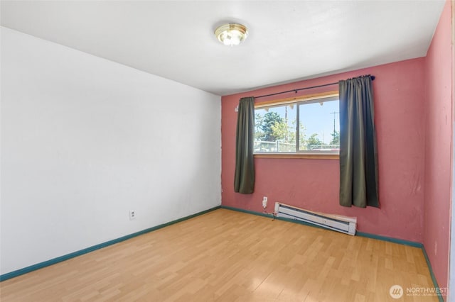 223 Carswell Dr, Moses Lake, WA 98837 - unfurnished room with baseboard heating, wood finished floors, and baseboards