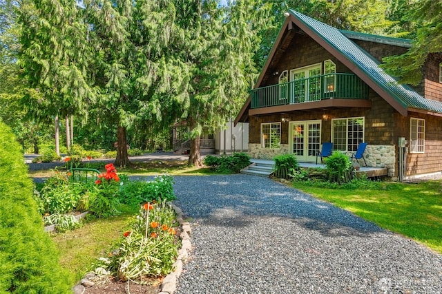 14030 Shuksan Rim Dr, Glacier, WA 98244 - view of front of home featuring a standing seam roof, french doors, a metal roof, stone siding, and driveway