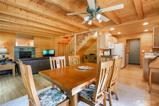 14030 Shuksan Rim Dr, Glacier, WA 98244 - dining space featuring wood walls, light wood-style flooring, a wood ceiling with exposed beams, ceiling fan, and stairs