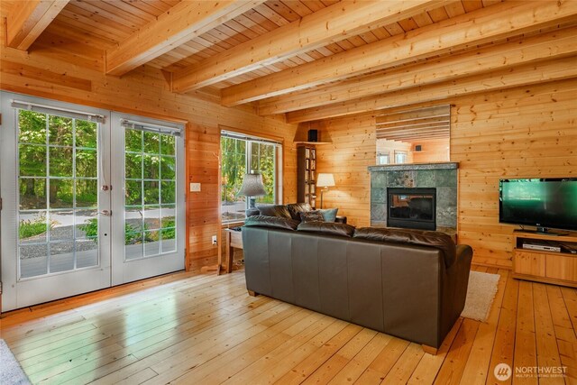 14030 Shuksan Rim Dr, Glacier, WA 98244 - living area with french doors, wooden walls, a wood ceiling with exposed beams, a fireplace, and light wood-style floors
