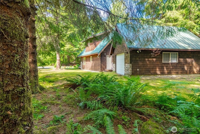 14030 Shuksan Rim Dr, Glacier, WA 98244 - view of side of home with an attached garage, a metal roof, and a lawn