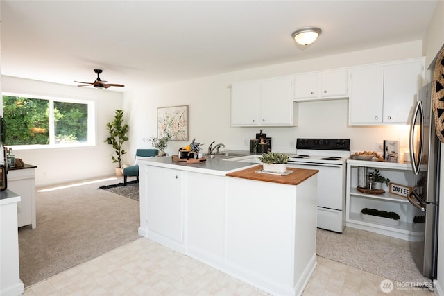 2029 S Charles St, Seattle, WA 98144 - kitchen with white electric range oven, freestanding refrigerator, ceiling fan, and light flooring