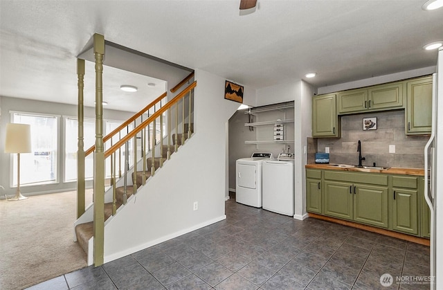 8805 11th St NE, Lake Stevens, WA 98258 - kitchen featuring green cabinets, a sink, washing machine and dryer, baseboards, and backsplash