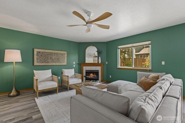 2004 15th Ave SW, Olympia, WA 98502 - living area featuring ceiling fan, wood finished floors, a tiled fireplace, and a textured ceiling