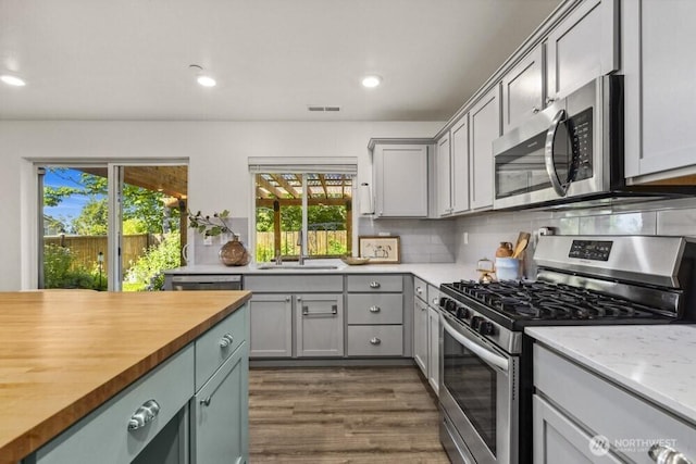 1709 Fern St SW, Olympia, WA 98502 - kitchen featuring appliances with stainless steel finishes, butcher block counters, healthy amount of natural light, dark wood-style floors, and recessed lighting