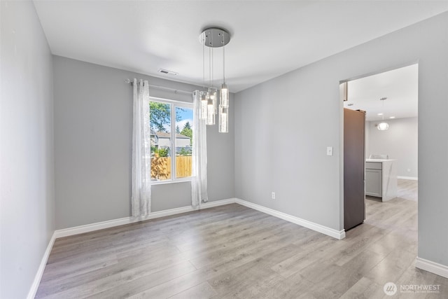 20602 86th Avenue Ct E, Spanaway, WA 98387 - spare room featuring light wood-style floors, baseboards, and a chandelier