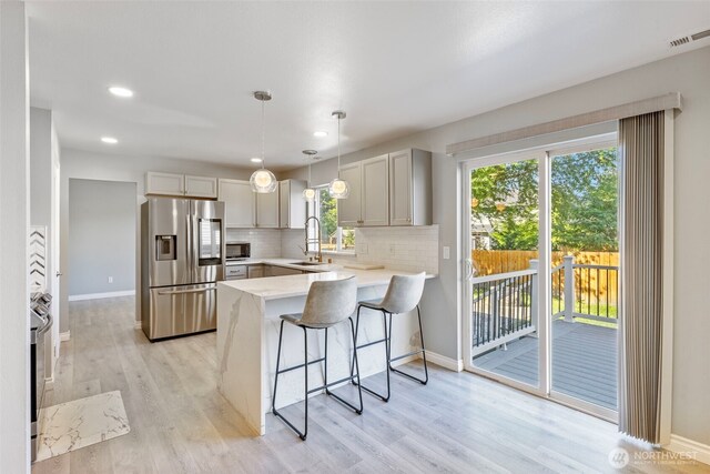 20602 86th Avenue Ct E, Spanaway, WA 98387 - kitchen featuring stainless steel fridge, a peninsula, a sink, a breakfast bar, and baseboards
