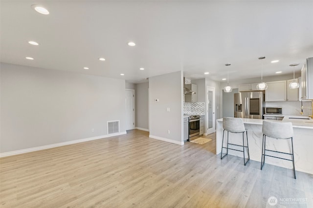 20602 86th Avenue Ct E, Spanaway, WA 98387 - kitchen featuring appliances with stainless steel finishes, tasteful backsplash, recessed lighting, light countertops, and light wood-style floors