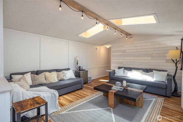 316 W Lake Samish Dr Unit 10, Bellingham, WA 98229 - living area with a skylight, wood finished floors, track lighting, and a decorative wall