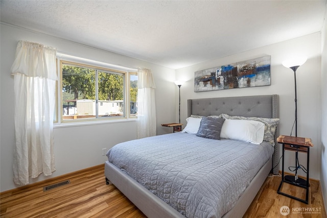 316 W Lake Samish Dr Unit 10, Bellingham, WA 98229 - bedroom featuring wood finished floors, baseboards, and a textured ceiling