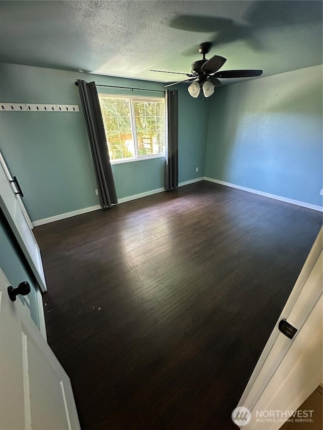 4776 Prairie Ln, Sedro Woolley, WA 98284 - spare room with dark wood-style flooring, ceiling fan, baseboards, and a textured ceiling