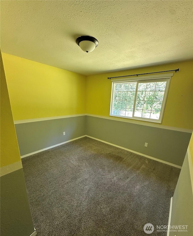 4776 Prairie Ln, Sedro Woolley, WA 98284 - spare room featuring a textured ceiling, dark carpet, and baseboards