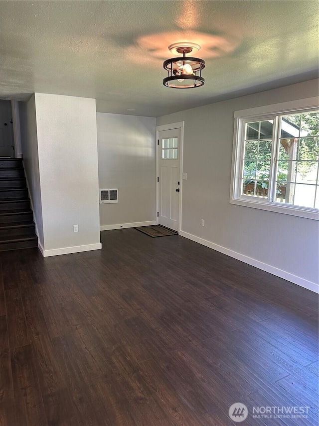 4776 Prairie Ln, Sedro Woolley, WA 98284 - unfurnished living room featuring dark wood-style flooring, baseboards, stairway, and a textured ceiling