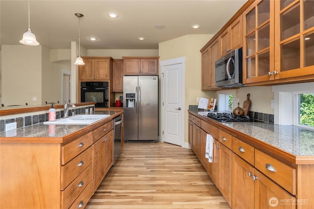 6412 122nd Street Ct E, Puyallup, WA 98373 - kitchen featuring stainless steel appliances, brown cabinets, light wood finished floors, tile countertops, and pendant lighting