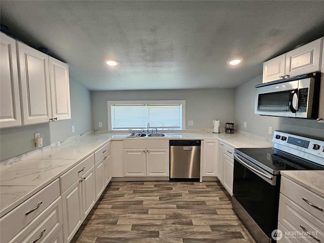 903 W Franklin St, Shelton, WA 98584 - kitchen with stainless steel appliances, dark wood-type flooring, white cabinetry, recessed lighting, and a textured ceiling