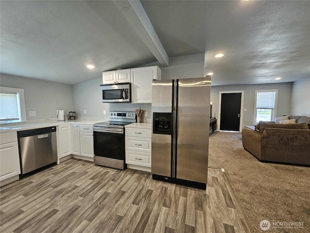 903 W Franklin St, Shelton, WA 98584 - kitchen featuring stainless steel appliances, white cabinets, light countertops, open floor plan, and wood finished floors