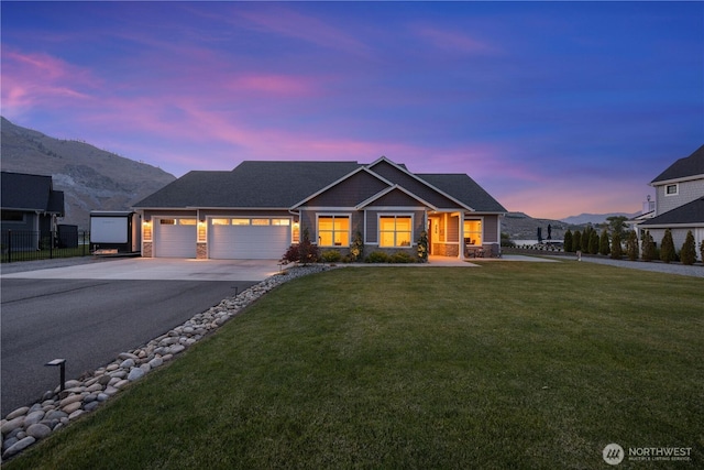 167 N Shore Dr, Orondo, WA 98843 - view of front facade with asphalt driveway, stone siding, a garage, and a mountain view