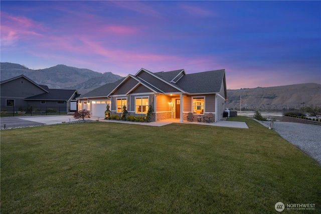 167 N Shore Dr, Orondo, WA 98843 - view of front facade with stone siding, driveway, an attached garage, covered porch, and a mountain view