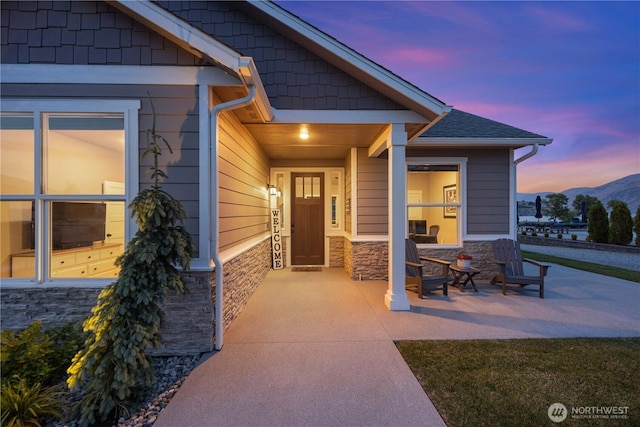 167 N Shore Dr, Orondo, WA 98843 - exterior entry at dusk featuring stone siding and a mountain view