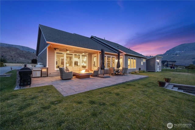 167 N Shore Dr, Orondo, WA 98843 - back of property with a storage unit, a patio area, ceiling fan, outdoor lounge area, and roof with shingles