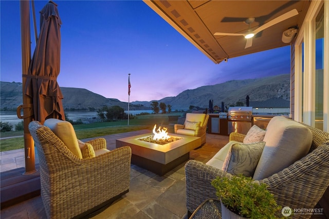 167 N Shore Dr, Orondo, WA 98843 - view of patio with a mountain view, ceiling fan, an outdoor kitchen, and an outdoor living space with a fire pit